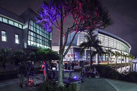 Two electronic musicians setup their gear near the student center at the Coral Gables campus while onlookers enjoy