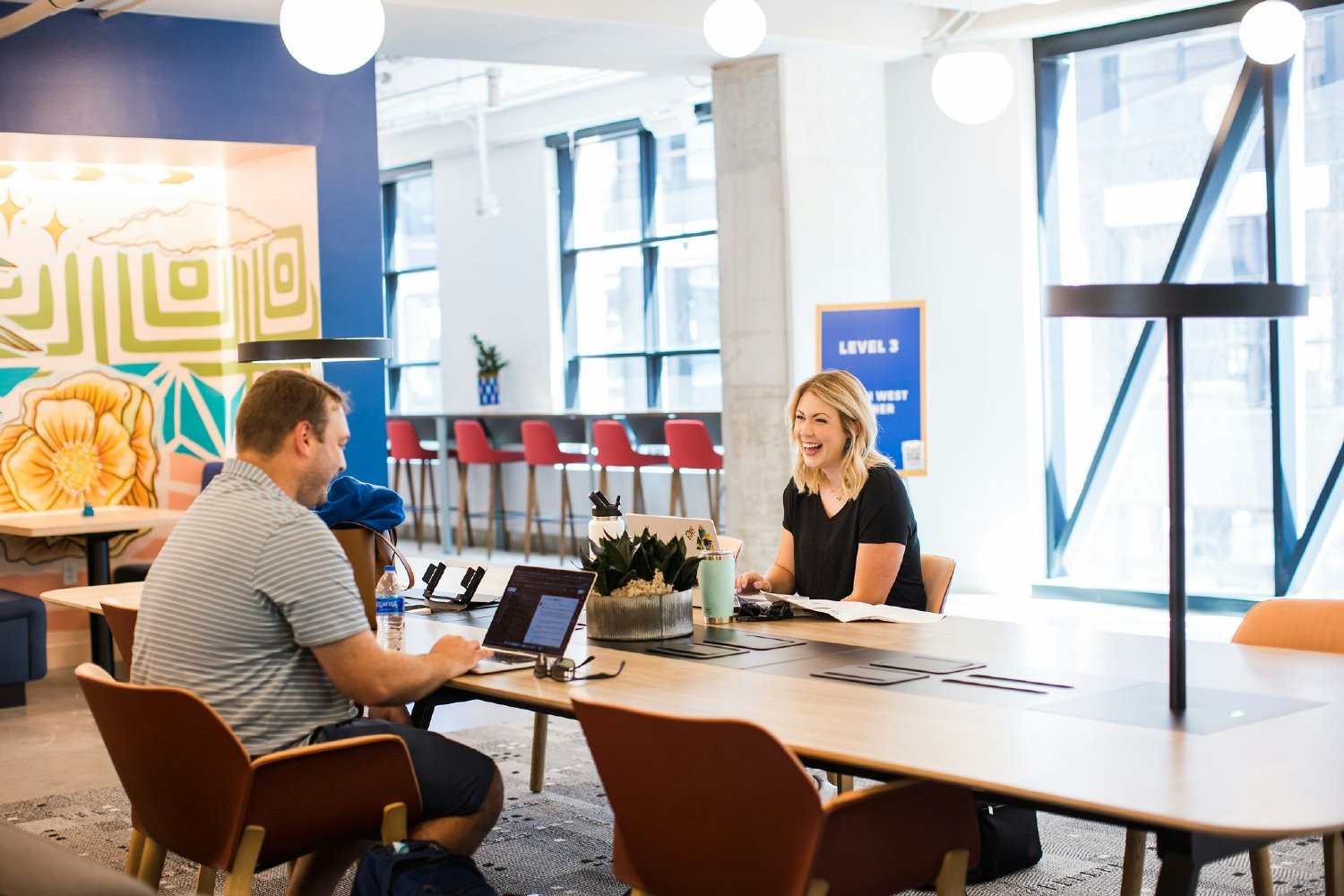  Atlassian's peer recognition program  is depicted with two coworkers having a conversation.