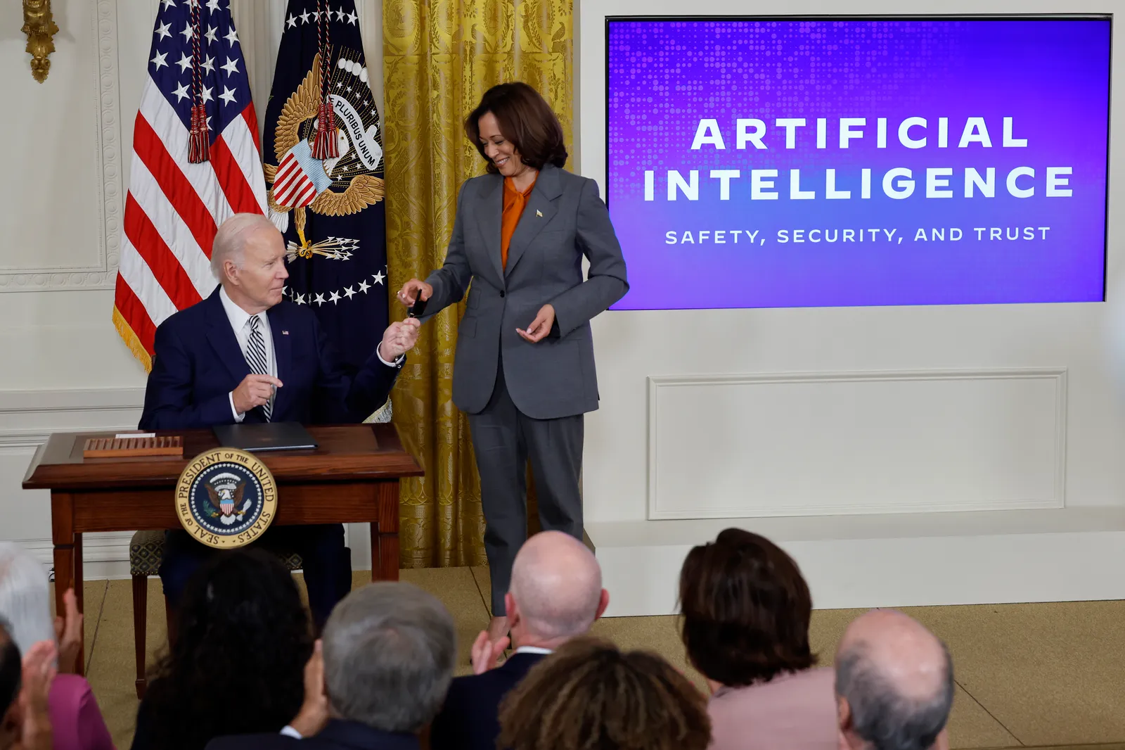 President Joe Biden hands Vice President Kamala Harris the pen he used to sign an executive order regarding artificial intelligence on October 30, 2023 in Washington, D.C.