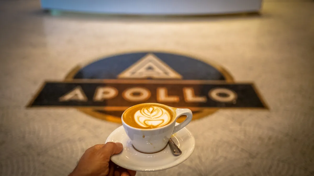 A person holds a cappuccino from The Wydown inside The Apollo on H Street NE.