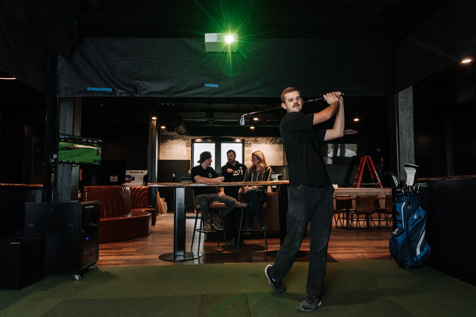 Assistant Pro Wyatt Johnson tests out a golf simulation bay at Urban Golf on the second floor at The Fairfield.