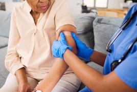 Nurse putting a bandaid on a woman's arm post-vaccine