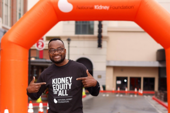 Anthony Tuggle posing at a Kidney Walk wearing his Kidney Equity for All t-shirt