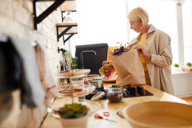 Una persona pone los comestibles en la cocina.