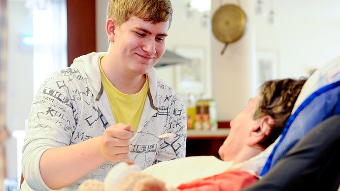 Ein Freiwilligendienstleistender reicht Essen an.