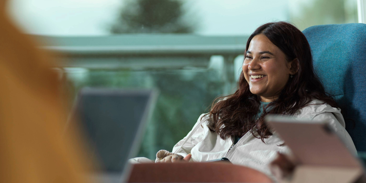 A female student in the infolab smiling 