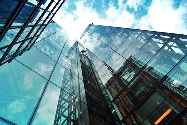 Modern city office buildings viewed from a sharp angle below.