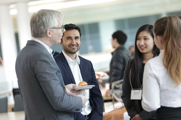 Professionals mingling over refreshments at an event.