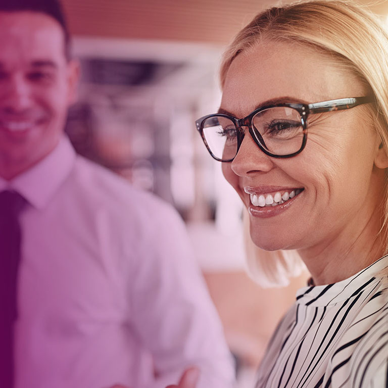 Smiling young businessman talking with colleagues during their coffee break together in a bright modern office