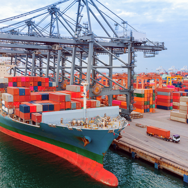 Aerial of cargo container ship carrying container under big crane loading cargo import and export service transportation at sea port.