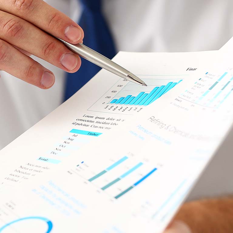 Businessman pointing to growing graph with silver pen