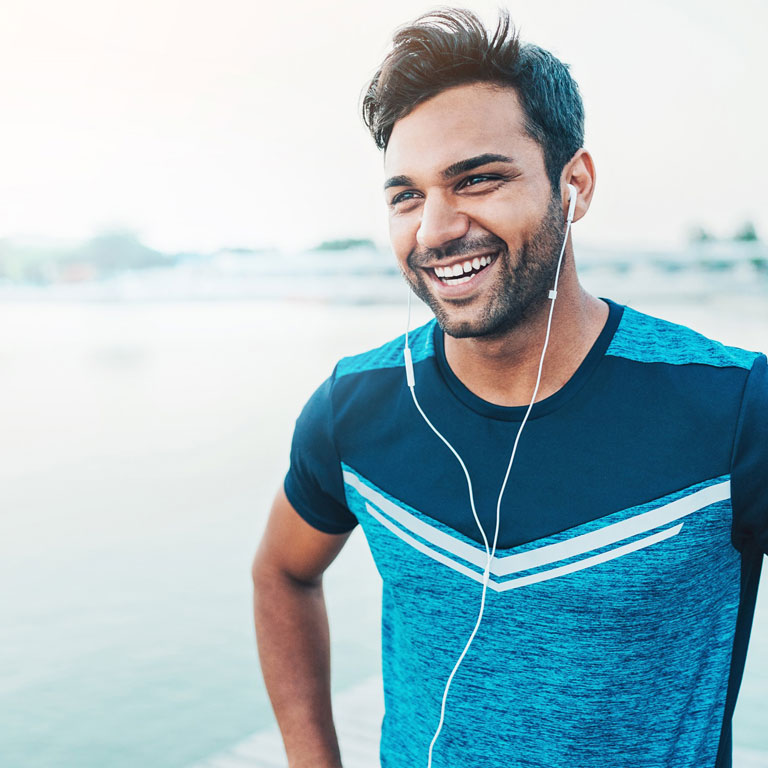 Athletic Asian man exercising happy and healthy in blue t-shirt listening to music
