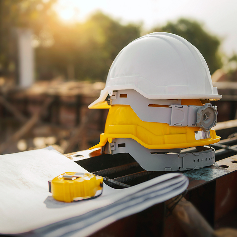 A stack of yellow and white helmets at a construction site.