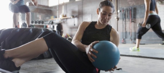 Three woman performing different exercises in a gym