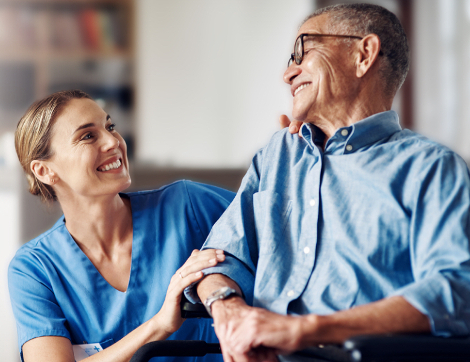 A man and his caregiver smile at each other.