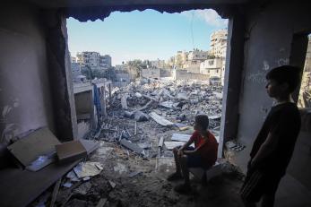 Children look out from the remains of a destroyed building in southern gaza. photo: ahmad salem/bloomberg via getty images