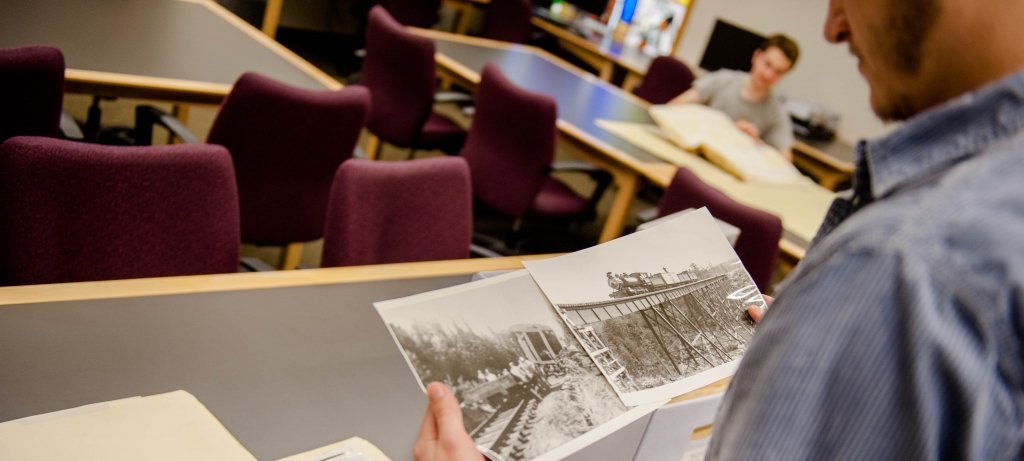 Person looking at black-and-white historical photos of the local area.