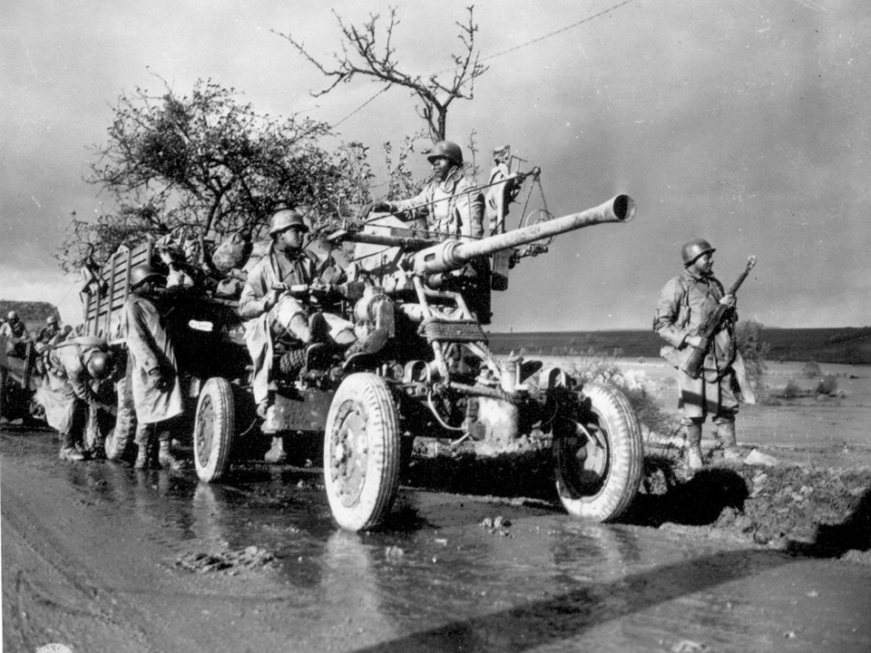 Soldiers man a cannon during the Battle of the Bulge