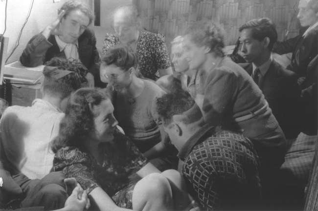 A group of Dutch resistance members and hidden Jews crowded into a room,