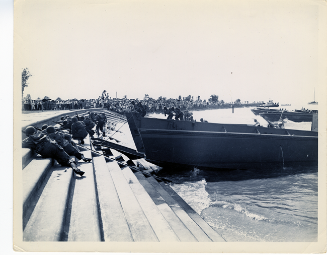 Servicemen climbing Lake Pontchartrain concrete beach from LCPLs