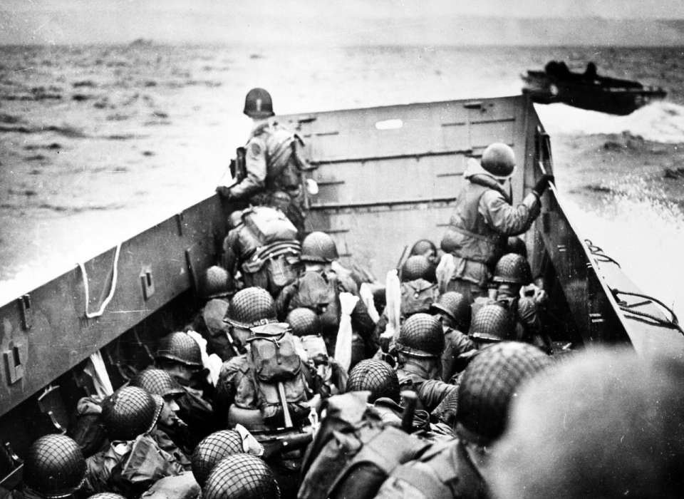 Troops crouch inside a LCVP landing craft