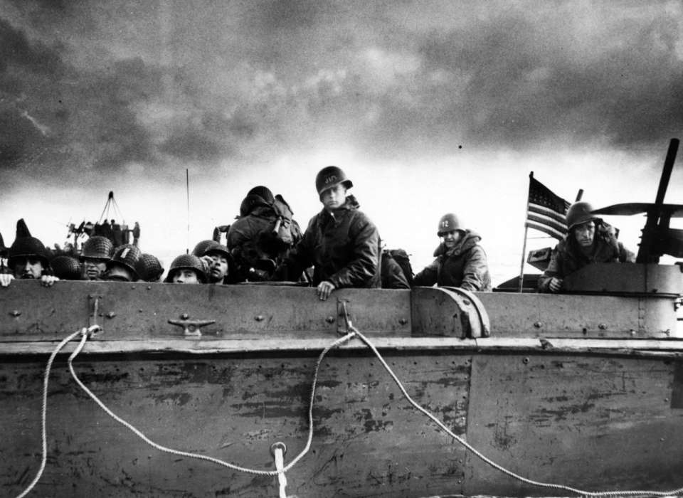 Troops and crewmen aboard a Coast Guard manned LCVP as it approaches a Normandy beach