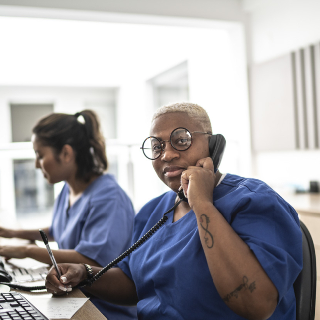 Portrait of secretary on telephone at hospital reception.