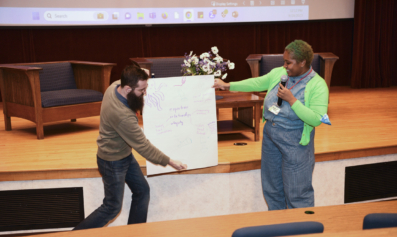 Two NELP employees share reflections from a group exercise, their poster reads "expertise, relationships, integrity..."