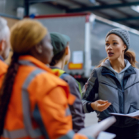 Female instructor guiding new truck drivers in safety procedures