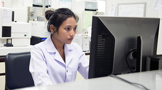 woman in a lab observing a computer monitor