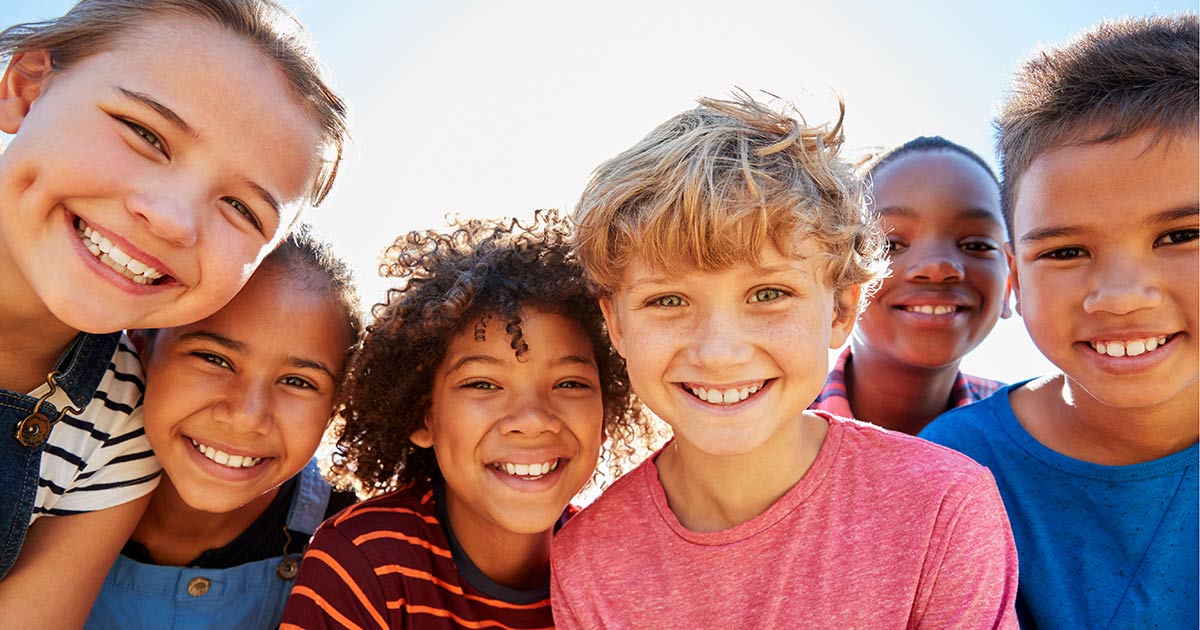 Group of children looking down into camera