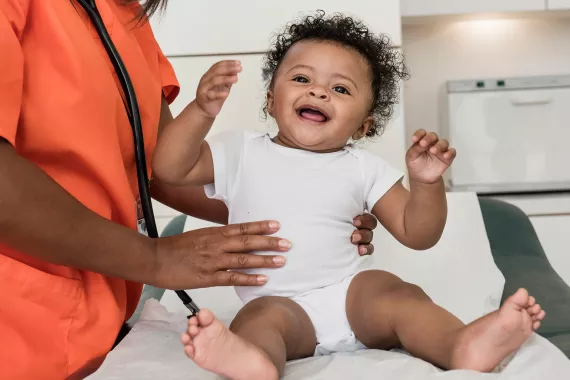 Infant patient being held by a healthcare professional during examination 