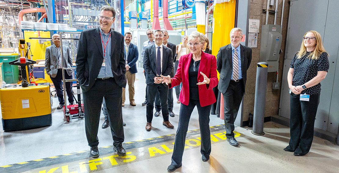 Ten people with safety glasses standing in the loading dock of a lab.