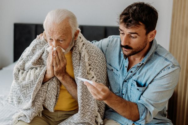 A man checking temperature of an older man