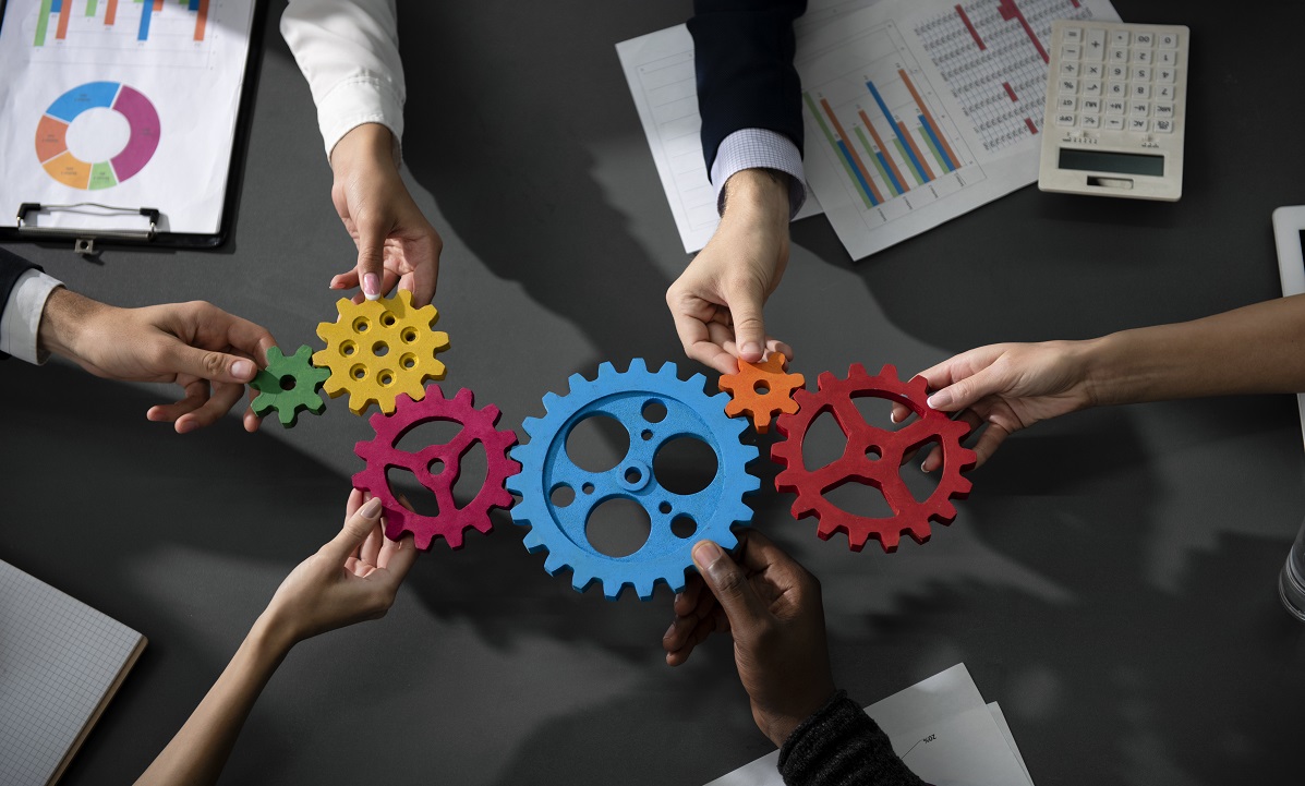 Teamwork of businesspeople work together and combine pieces of gears. Partnership and integration concept