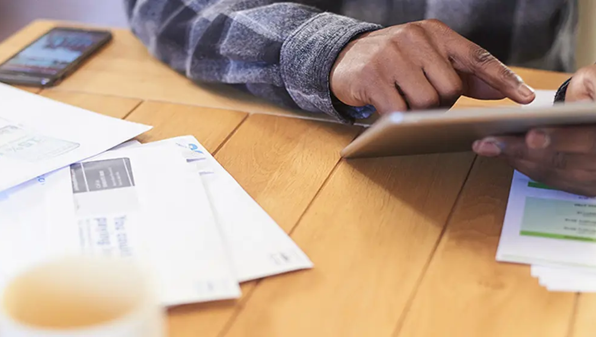 Man on tablet looking at bills