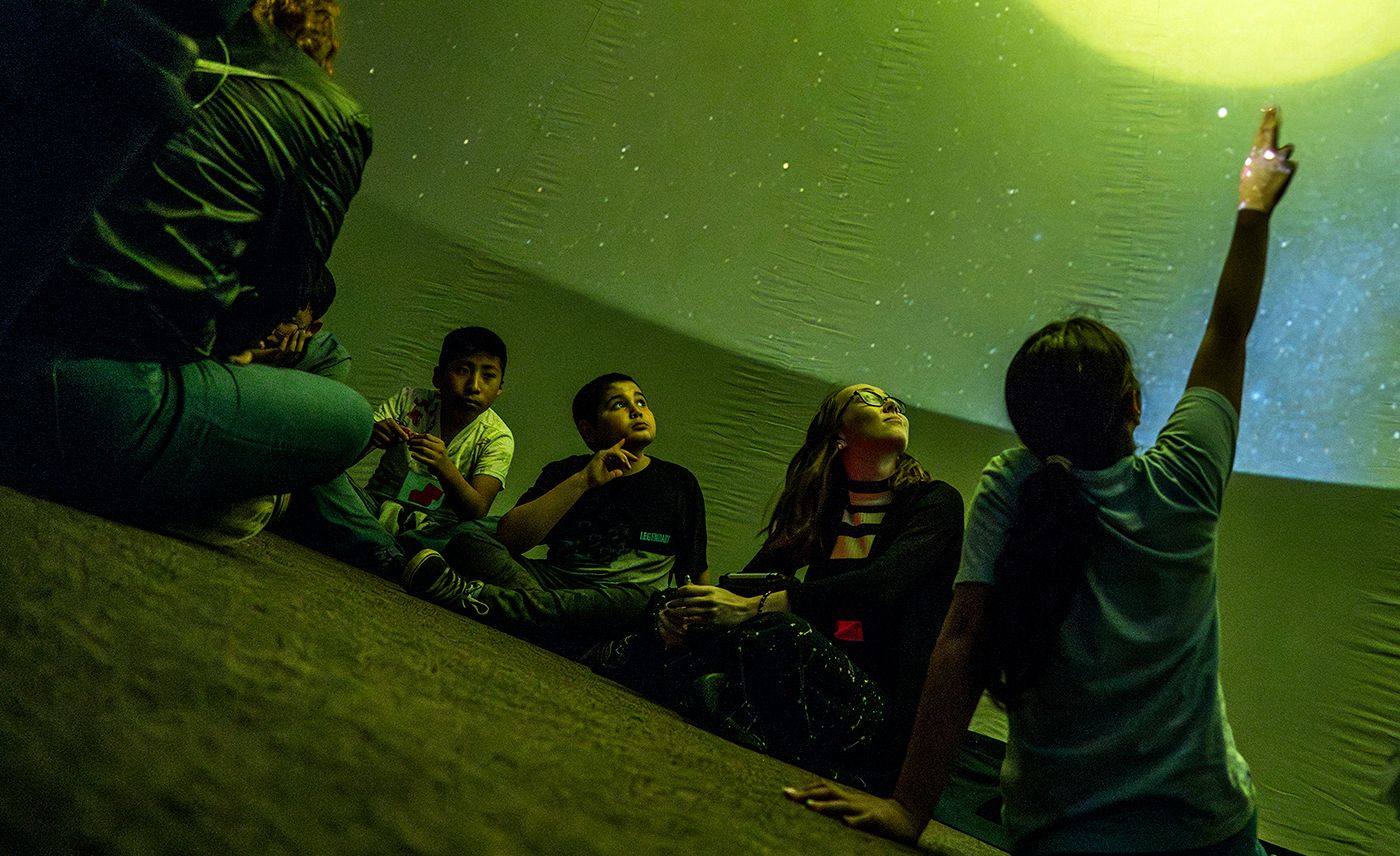 Young people observe the stars using Solstice Outreach's portable planetarium