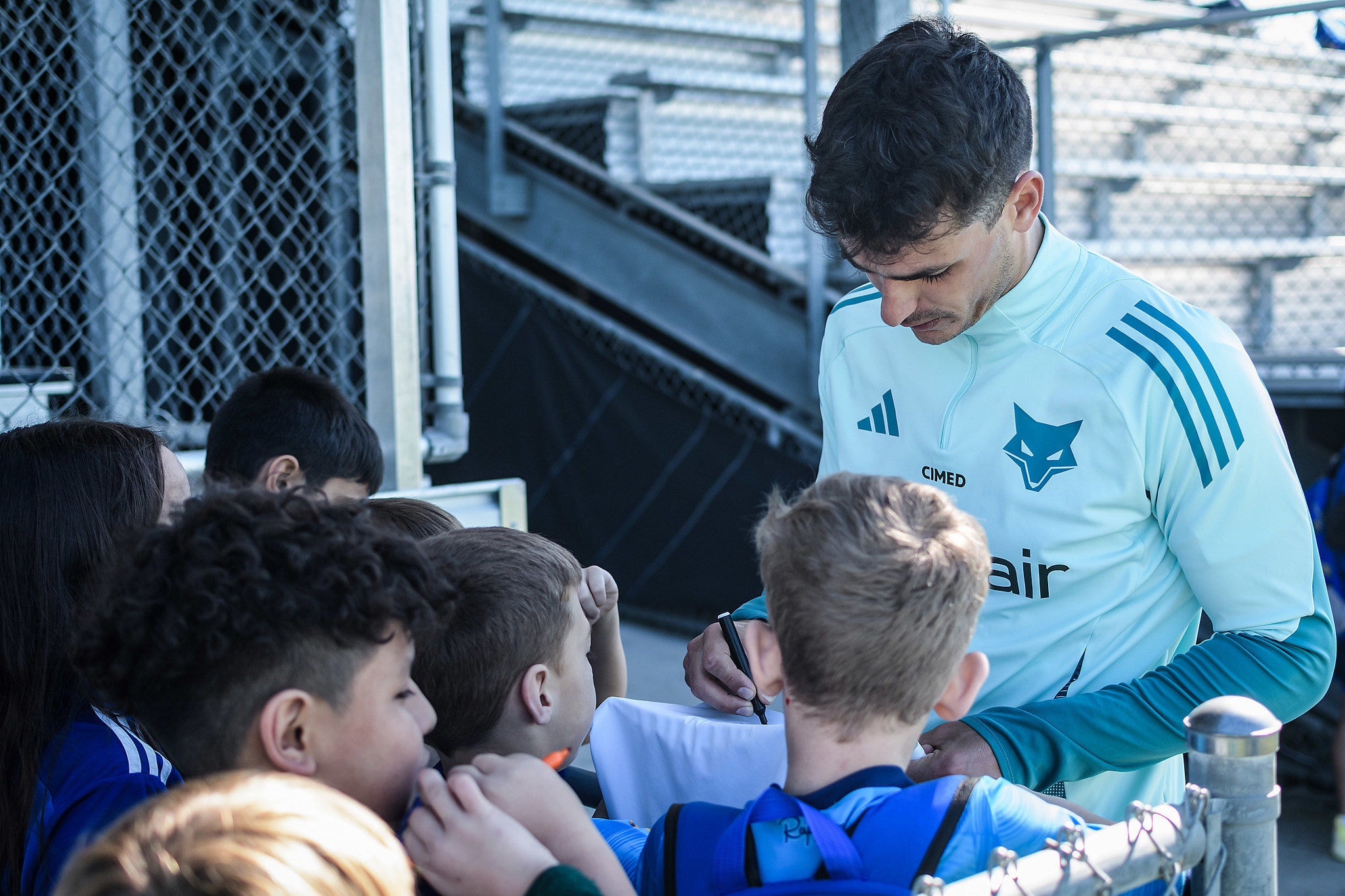 Juan Dinenno atendendo crianças durante treino