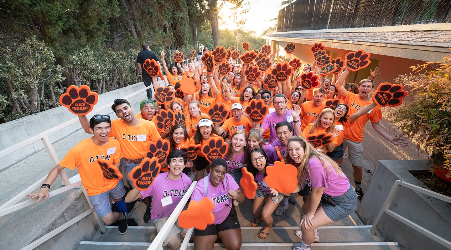 O Team students in a big crowd cheering in orange Oxy tshirts