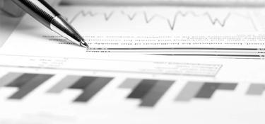 A pin and papers showing charts and graphs