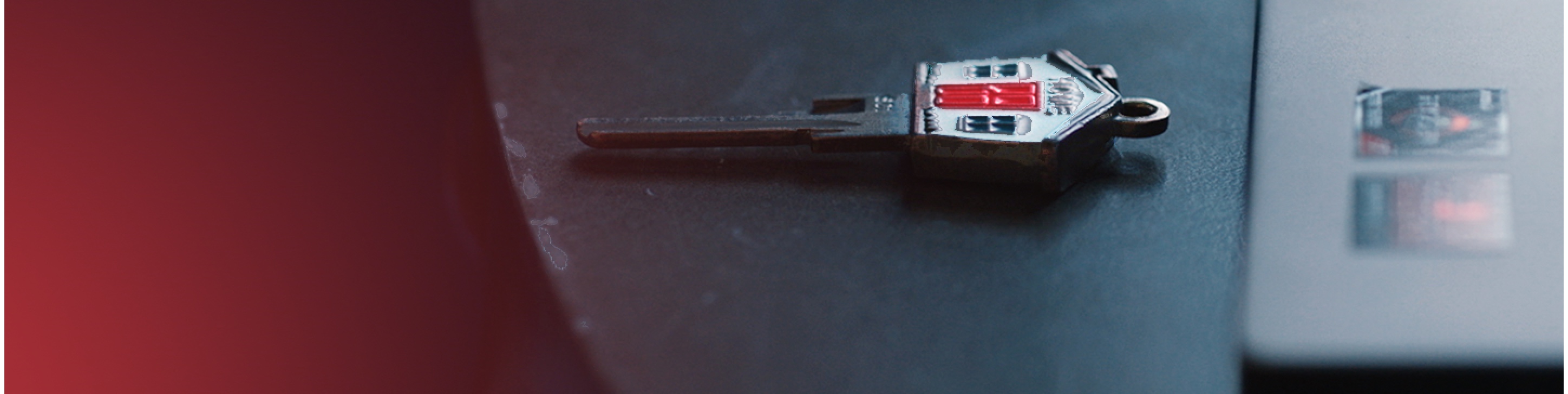 A house key sitting on a table next to a computer