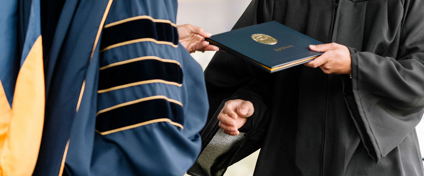 Student receiving their diploma at commencement 