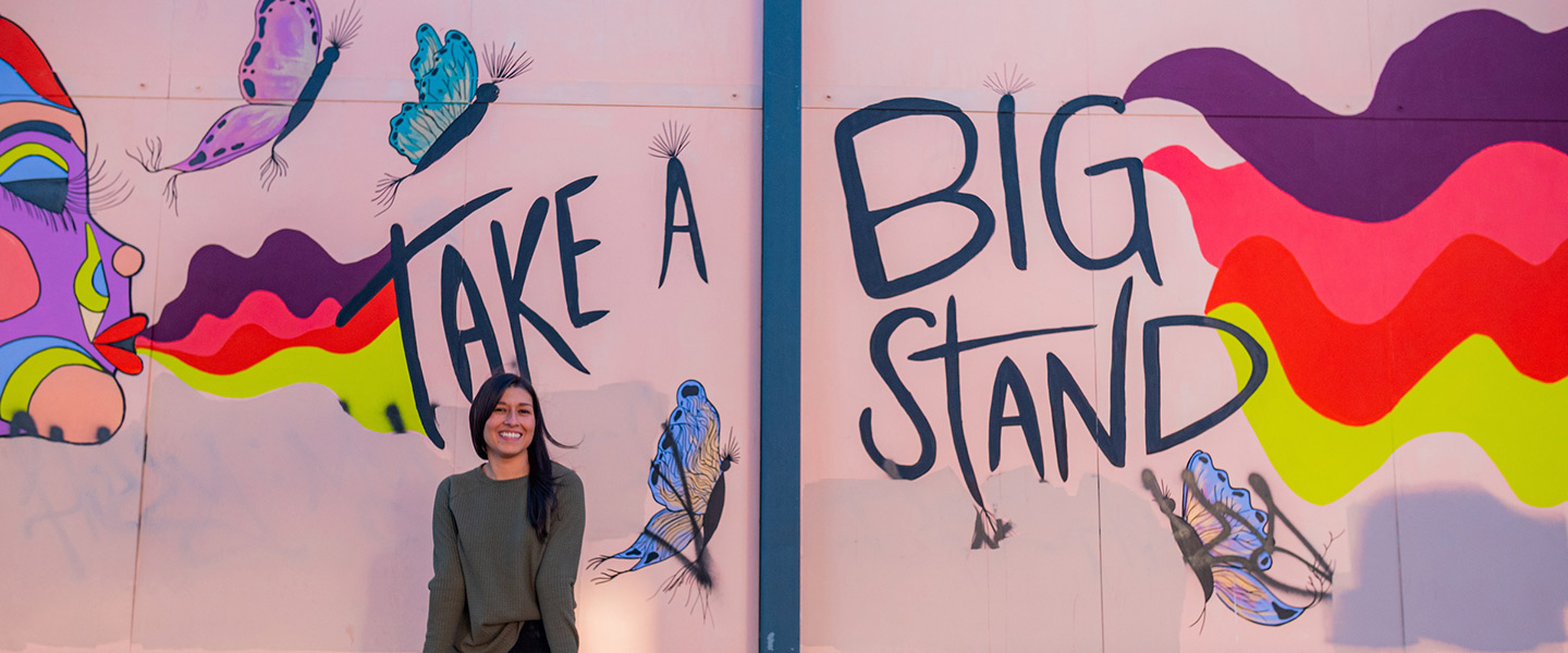 women in front of mural