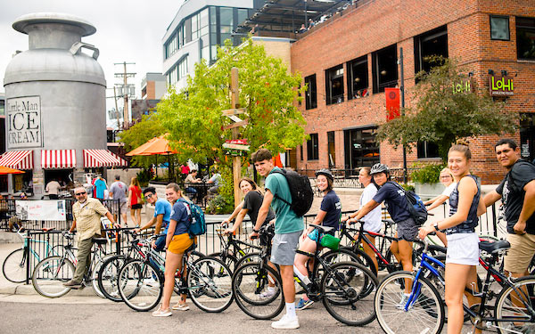 a group of students rides bikes to Little Man Ice Cream in the Highlands