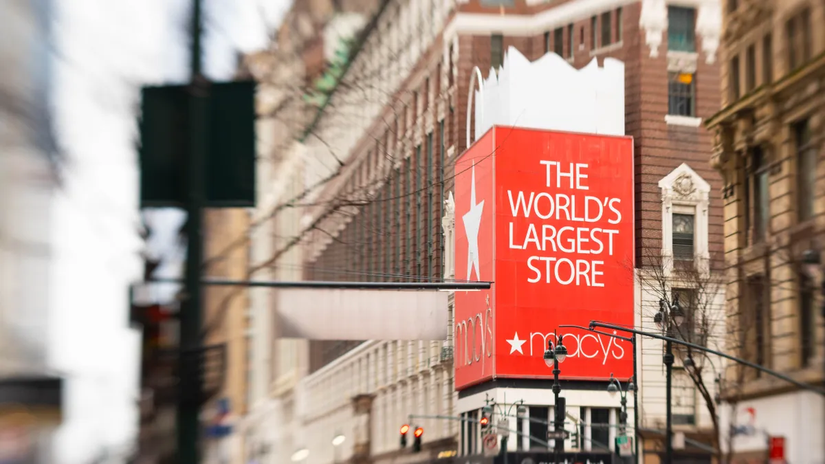 A big red sign on the side of a large department store building.