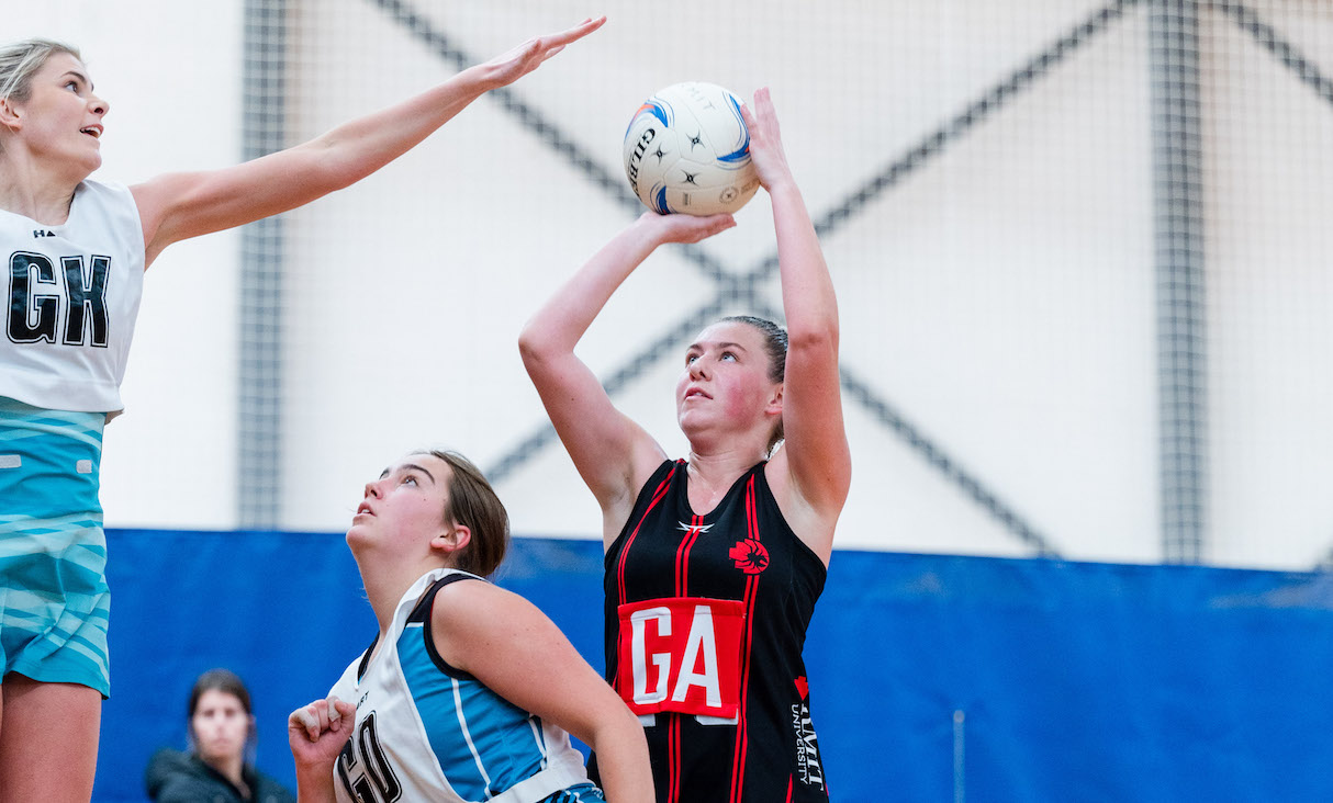 RMIT netballer shoots for goal.