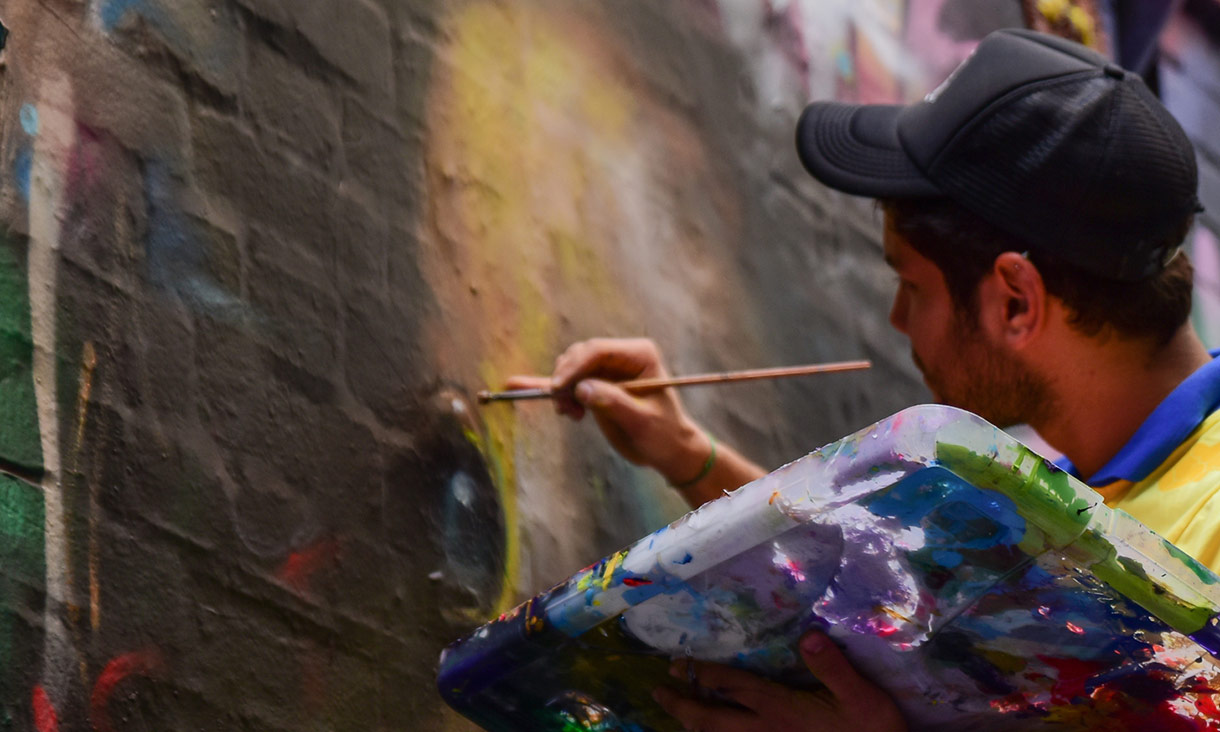 Main uses artist paintbrush on brick wall