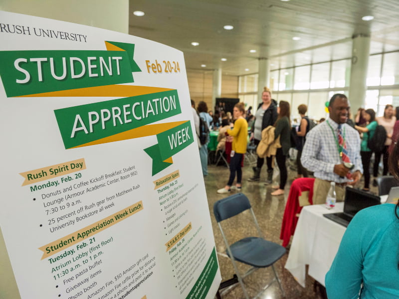 Students mingle in a large hall behind a sign reading Student Appreciation Week