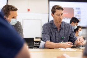 Students practice suturing in a classroom