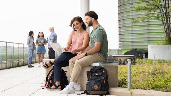 A rooftop gardenwhere students work on laptops and talk in small groups